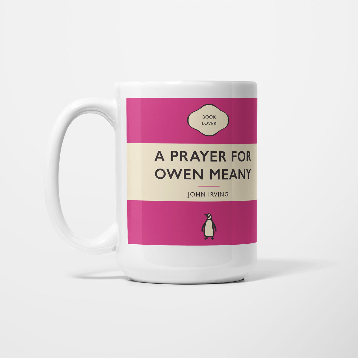The 15oz A Prayer For Owen Meany mug, white ceramic printed as a vintage paperback jacket in magenta and cream, reading 'A Prayer For Owen Meany' above John Irving