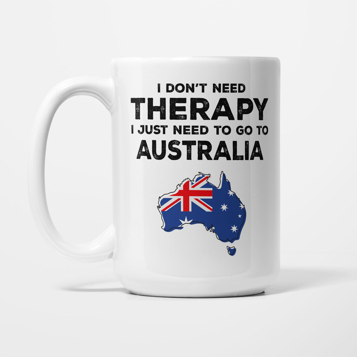 The 15oz I Need Australia mug, white ceramic in bold black type reading 'I don't need therapy, I just need to go to AUSTRALIA', above an outline of Australia filled with its national flag