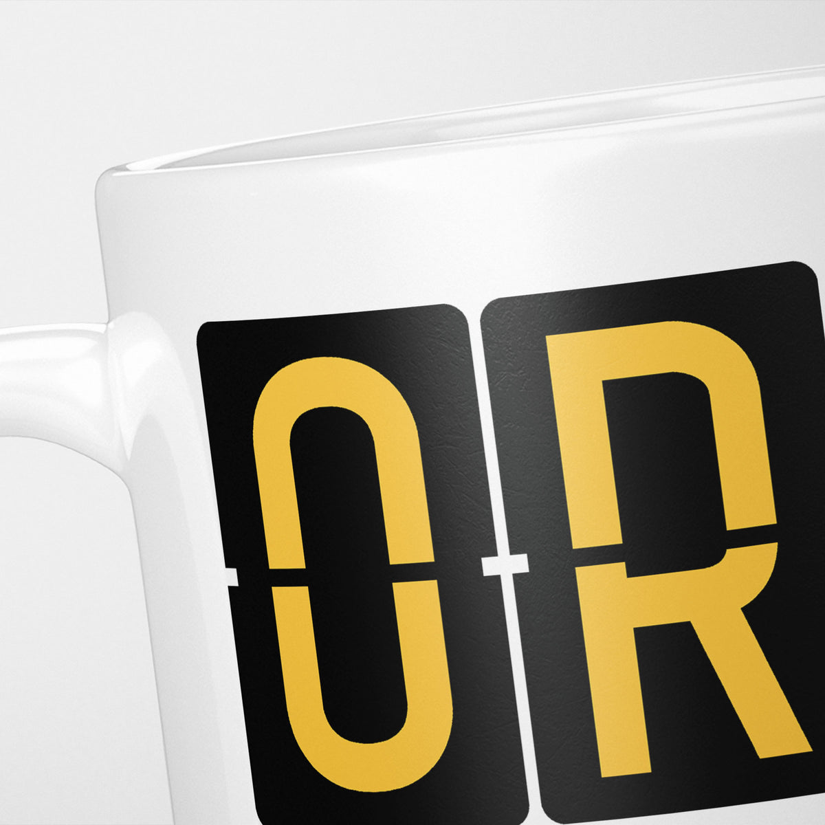 Close crop of the Cork Airport Tag mug, gold split-flap tiles reading 'O' and 'R' on black — the first two letters of ORK