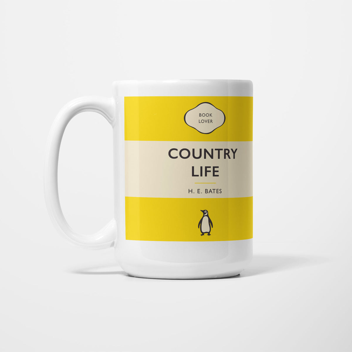 The 15oz Country Life mug, white ceramic printed as a vintage paperback jacket in yellow and cream, reading 'Country Life' above H. E. Bates