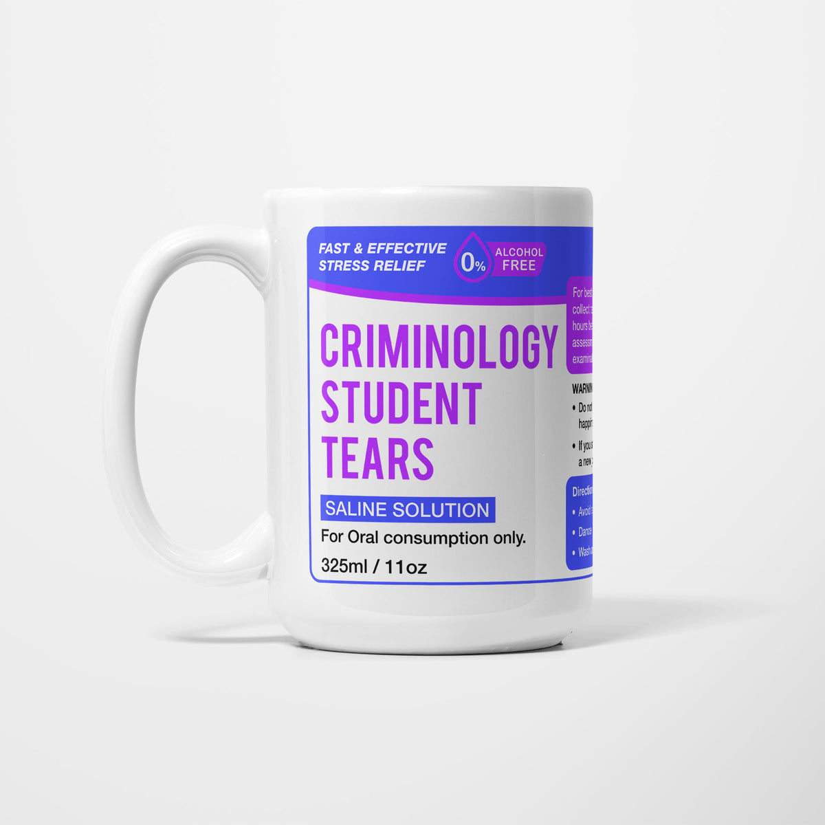 The 15oz Criminology Student Tears mug, white ceramic with a violet pharmacy-style label reading 'Criminology Student Tears — Saline Solution, for oral consumption only'