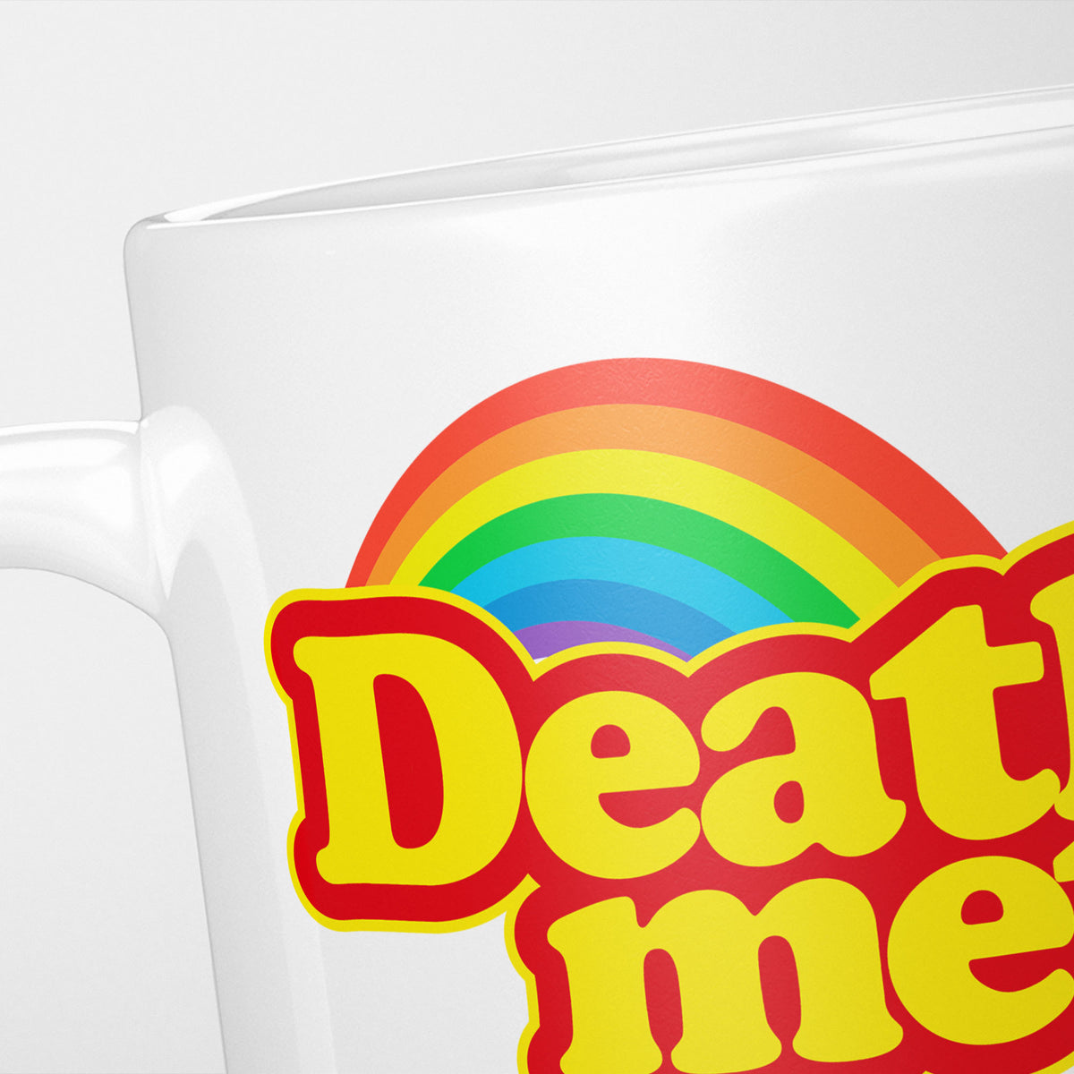 Close crop of the Death Metal Rainbow mug, the rainbow arc above 'Deat…' in red and yellow sweet-wrapper lettering