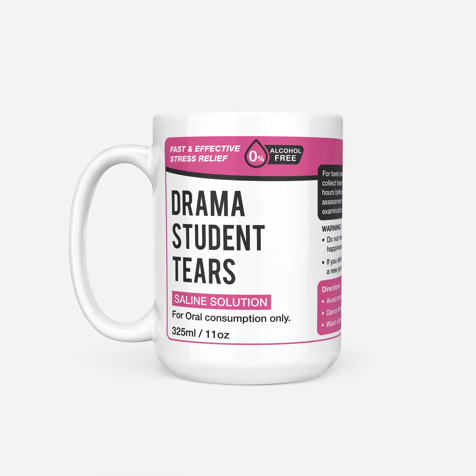 The 15oz Drama Student Tears mug, white ceramic with a magenta pharmacy-style label reading 'Drama Student Tears — Saline Solution, for oral consumption only'