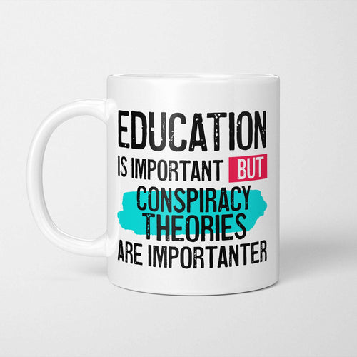 White ceramic mug with bold colourful text reading 'Education is Important but Conspiracy Theories are Importanter'