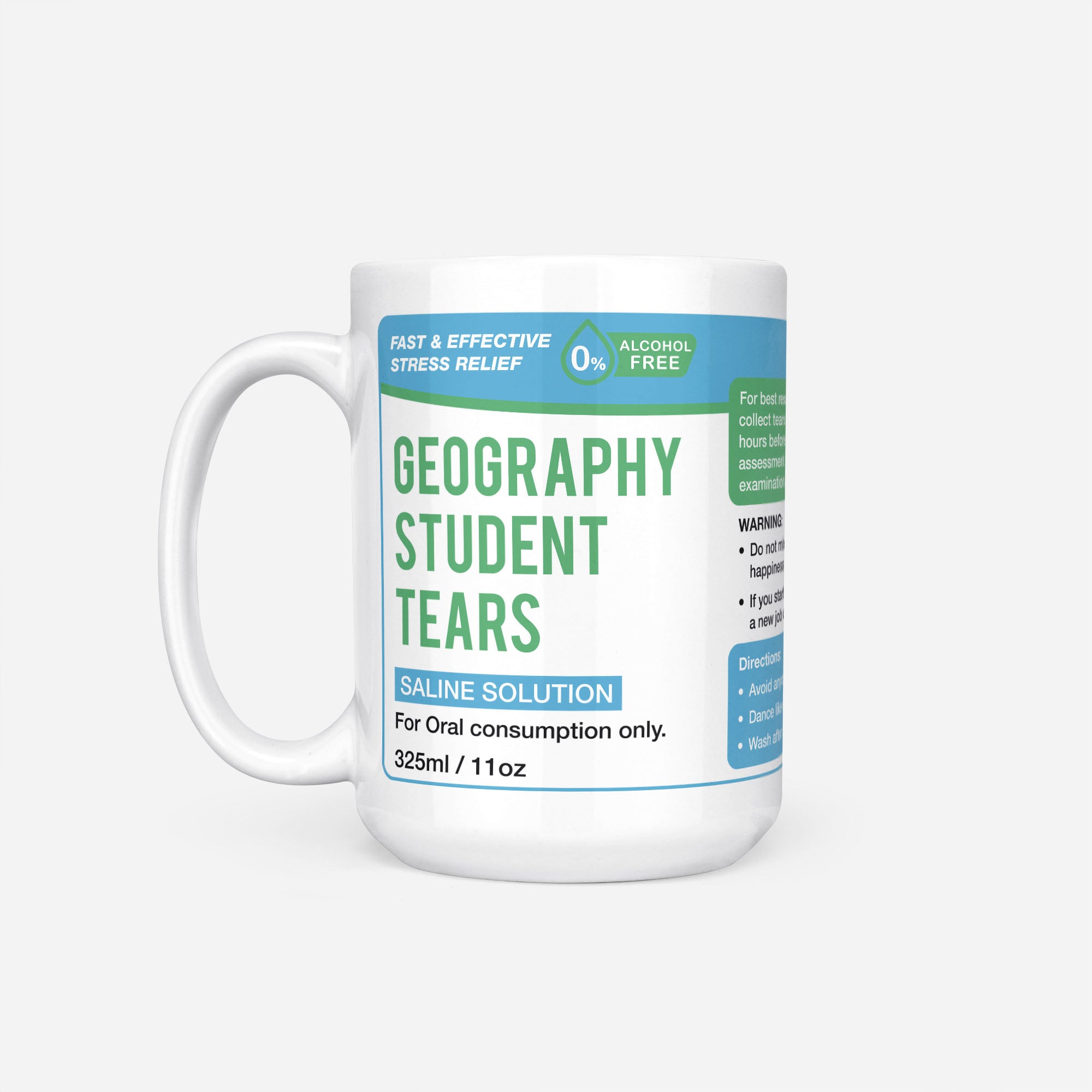 The 15oz Geography Student Tears mug, white ceramic with a blue pharmacy-style label reading 'Geography Student Tears — Saline Solution, for oral consumption only'