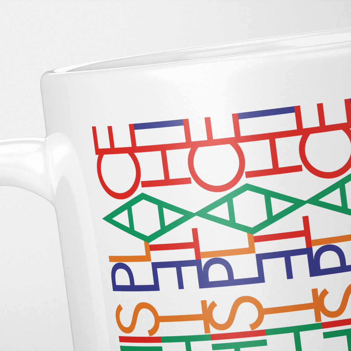 Close crop of the Funny Hidden Message "I Hate This Place" mug, rows of red, green, orange and blue interlocking letterforms