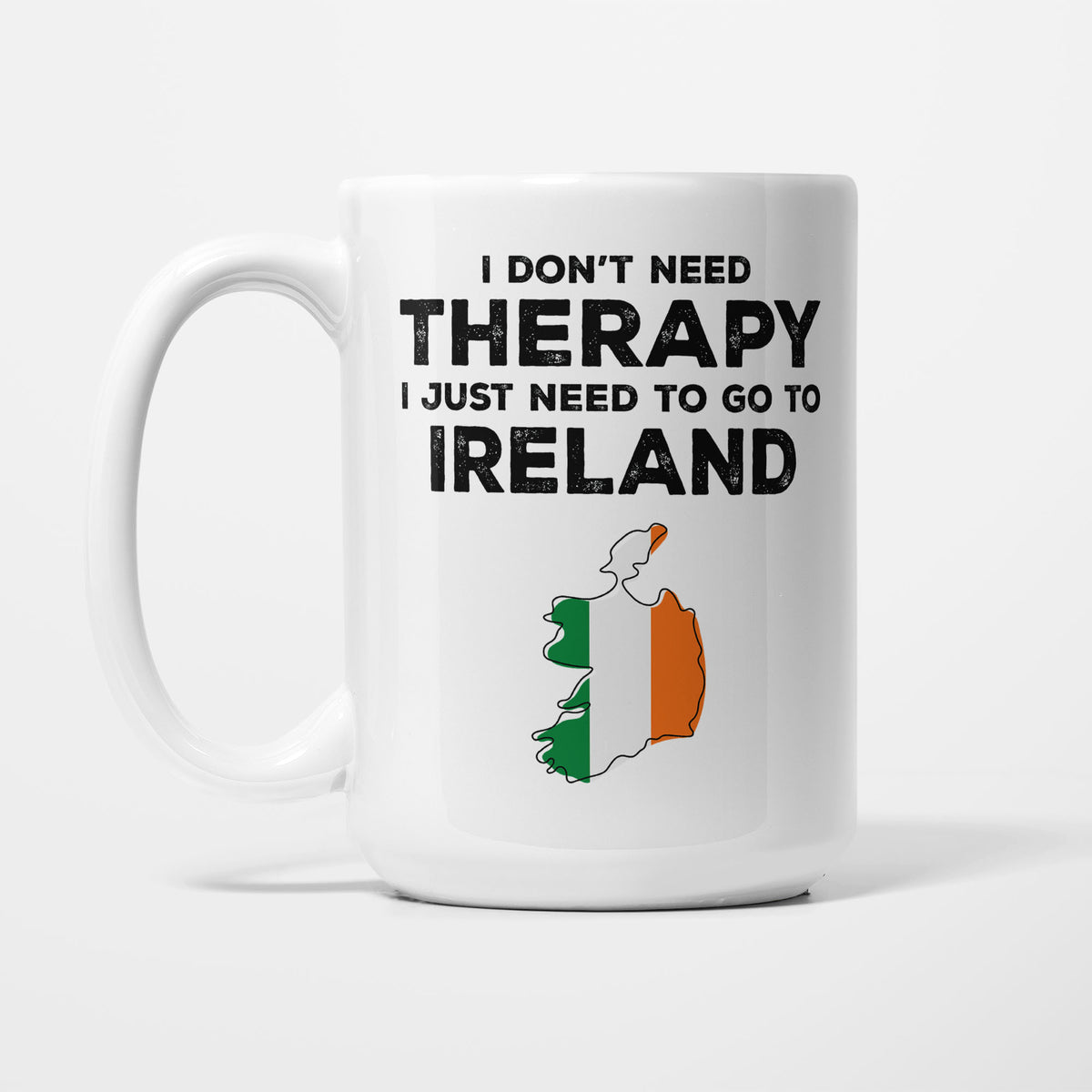 The 15oz I Need Ireland mug, white ceramic in bold black type reading 'I don't need therapy, I just need to go to IRELAND', above an outline of Ireland filled with its national flag