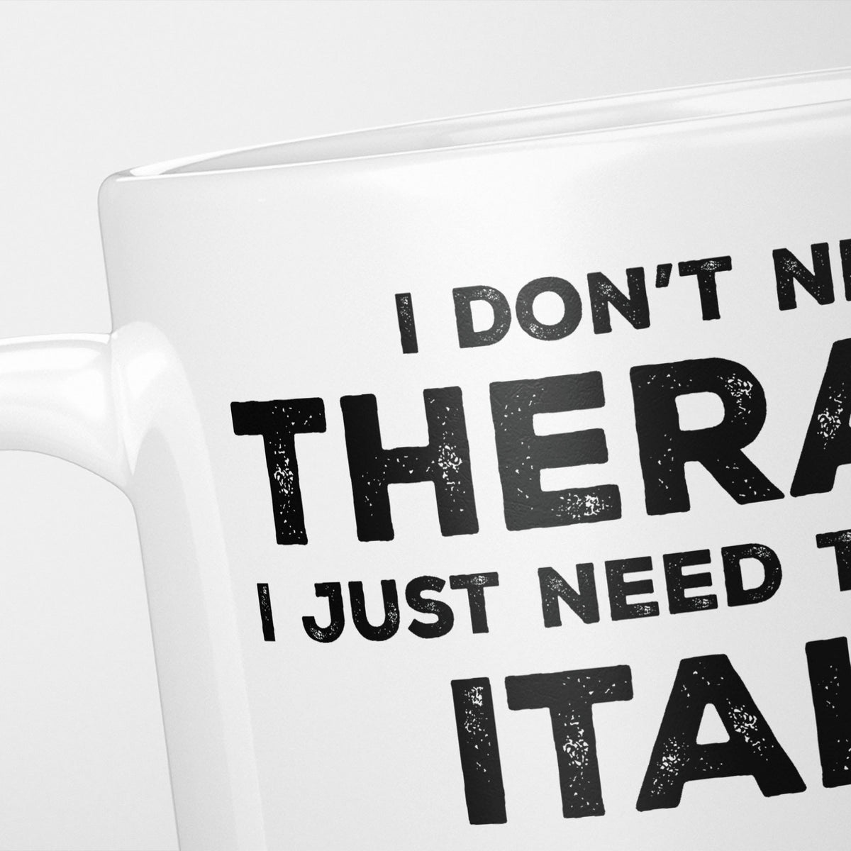 Close crop of the I Need Italy mug, 'I don't need therapy, I just need to go to ITALY' in heavy distressed black type, running off the edges of the frame