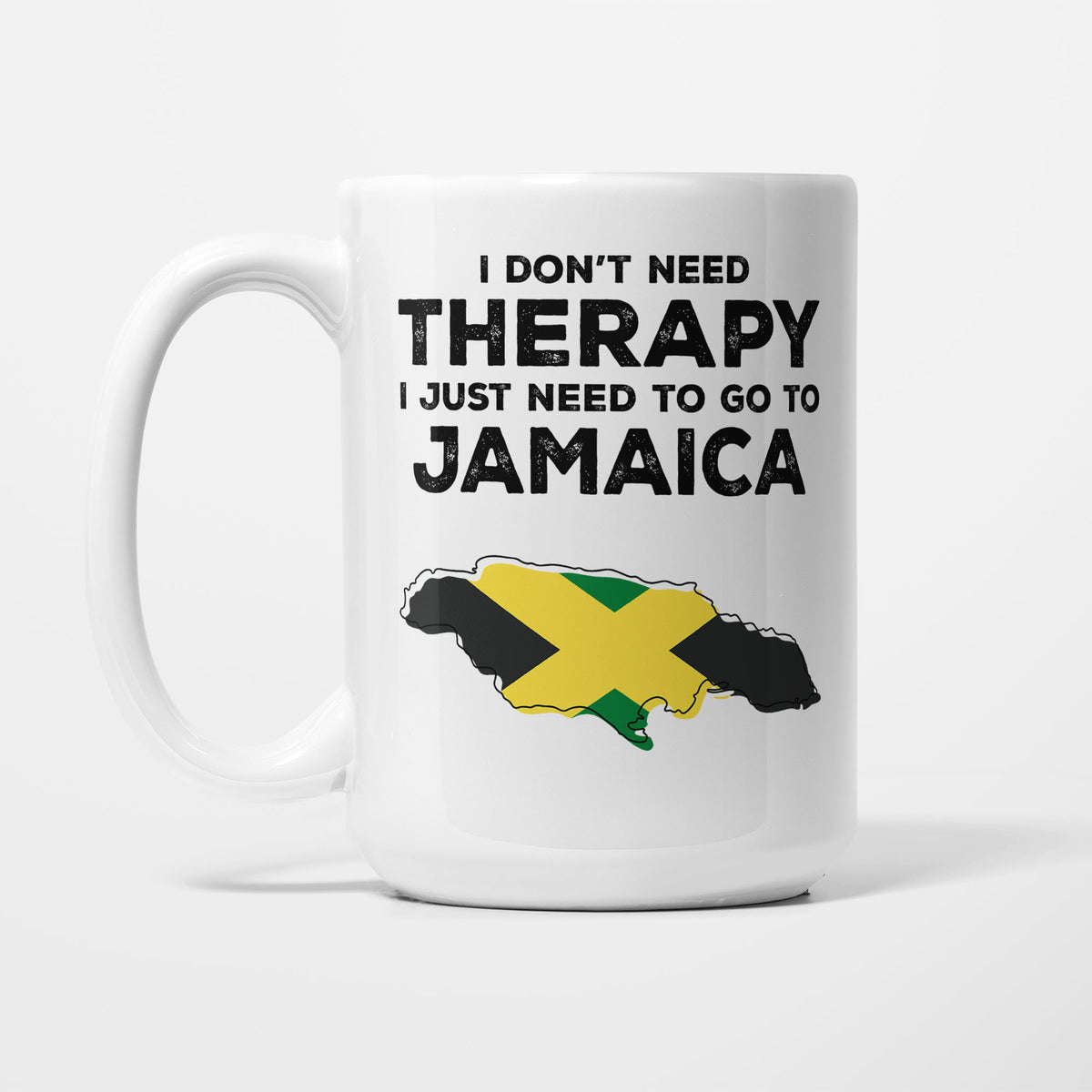 The 15oz I Need Jamaica mug, white ceramic in bold black type reading 'I don't need therapy, I just need to go to JAMAICA', above an outline of Jamaica filled with its national flag