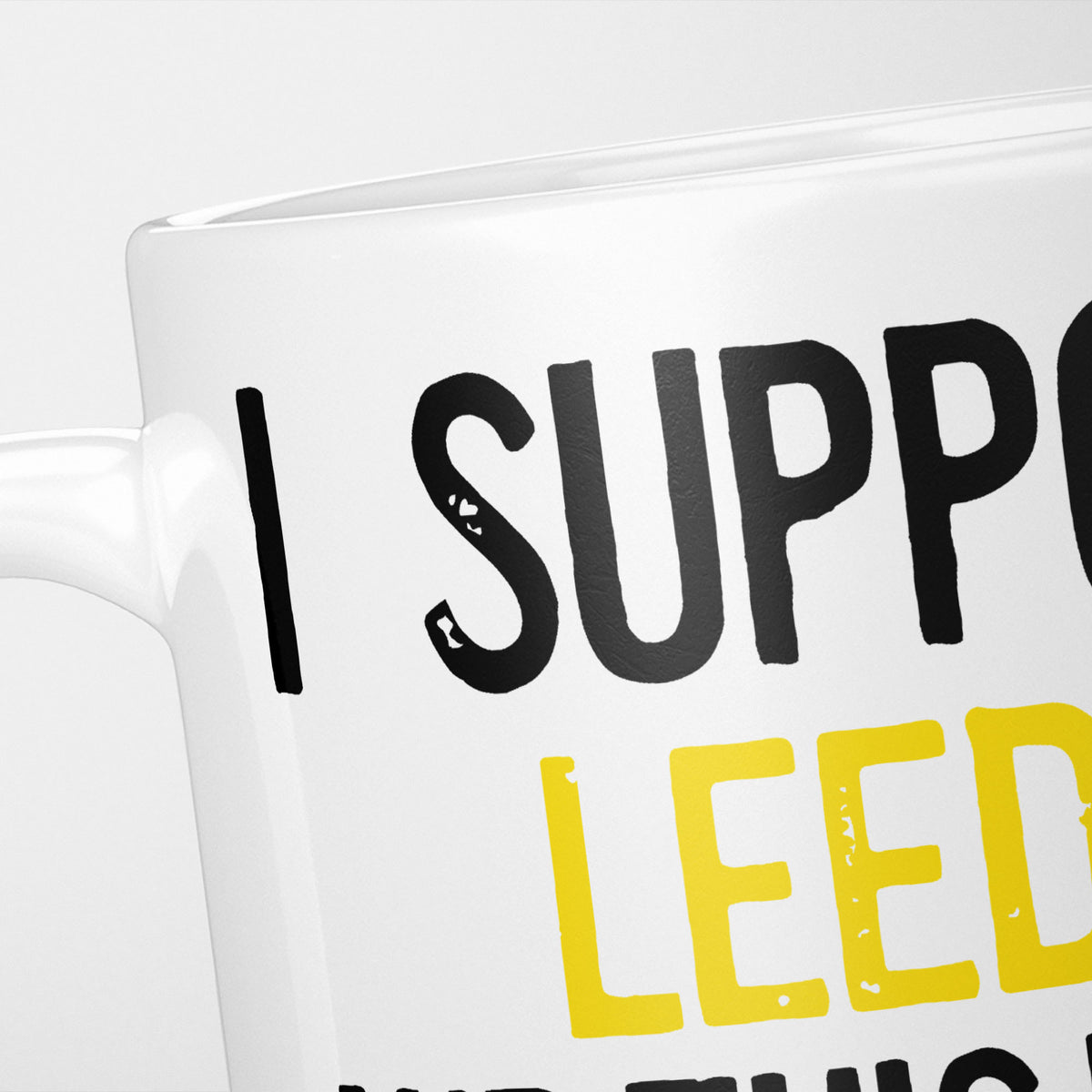 Close crop of the I Support Leeds mug, 'I Support' in heavy black above the club name in yellow, running off the edge of the frame