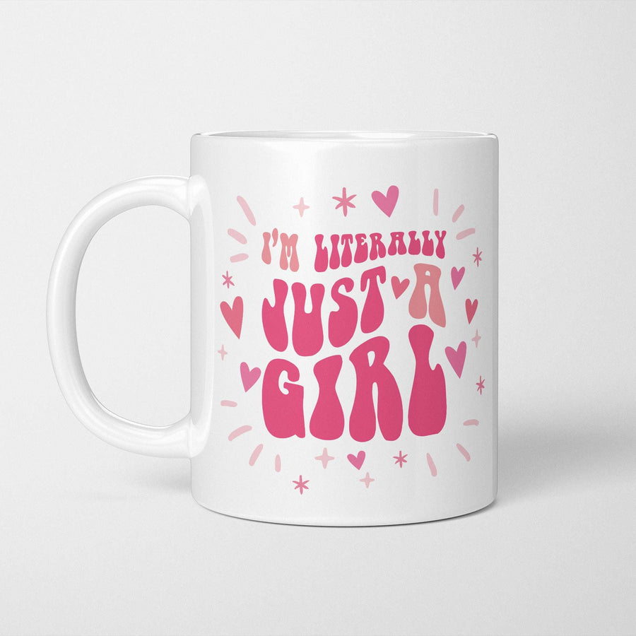 White ceramic reading 'I'm literally just a girl' in pink retro bubble lettering among scattered hearts and sparkles