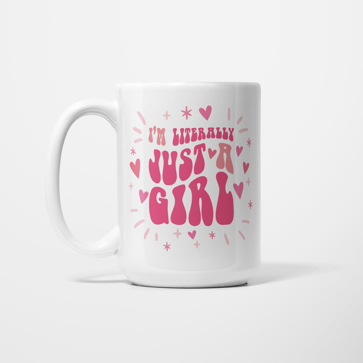 The 15oz I'm Literally Just a Girl mug, white ceramic reading 'I'm literally just a girl' in pink retro bubble lettering among scattered hearts and sparkles