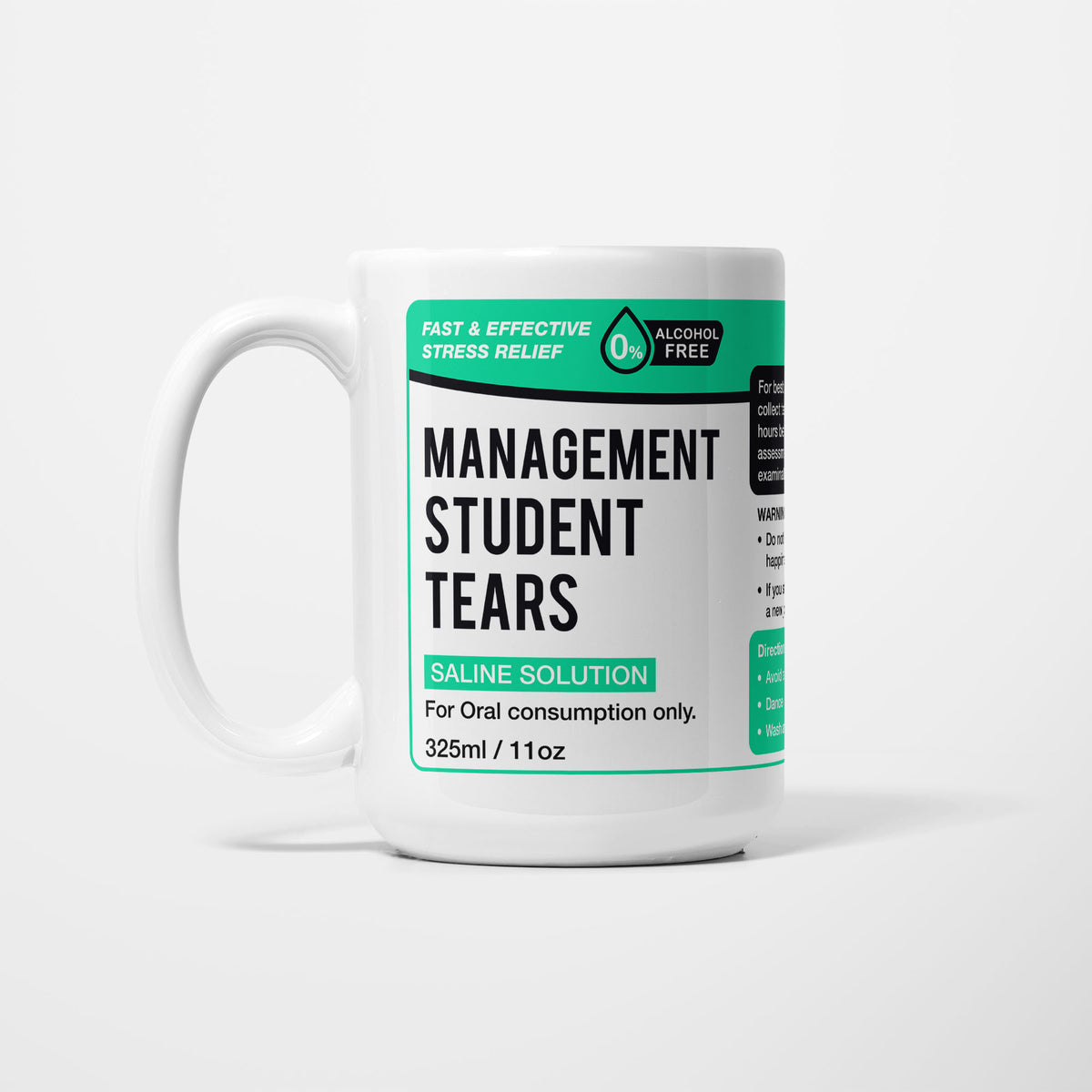 The 15oz Management Student Tears mug, white ceramic with a green pharmacy-style label reading 'Management Student Tears — Saline Solution, for oral consumption only'