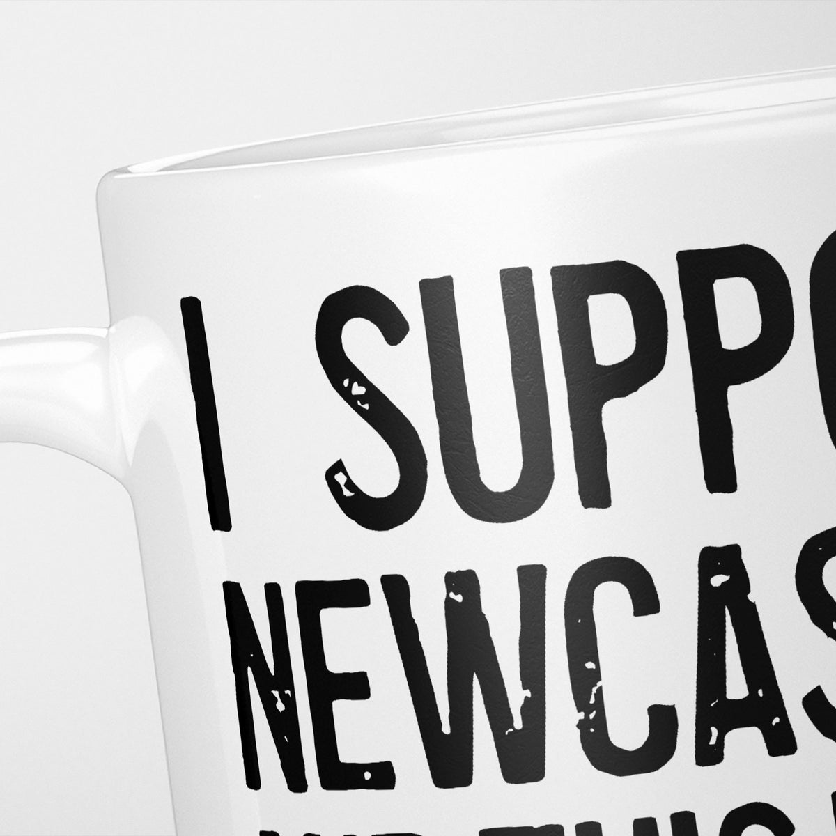 Close crop of the I Support Newcastle mug, 'I Support' above the club name in heavy black type, running off the edge of the frame