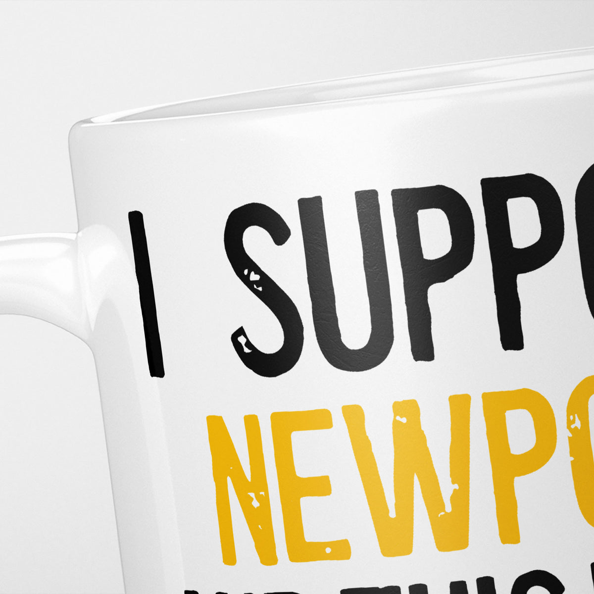 Close crop of the I Support Newport mug, 'I Support' in heavy black above the club name in amber, running off the edge of the frame
