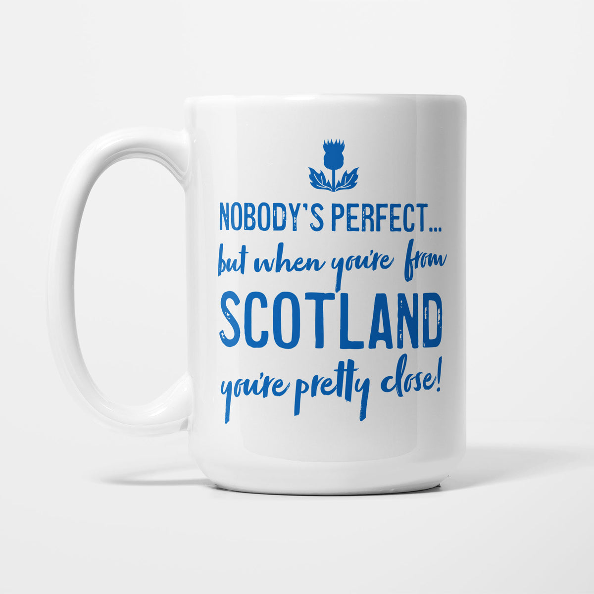 The 15oz Nobody's Perfect Scotland mug, white ceramic reading 'Nobody's perfect... but when you're from SCOTLAND you're pretty close!' in blue lettering beneath a blue thistle