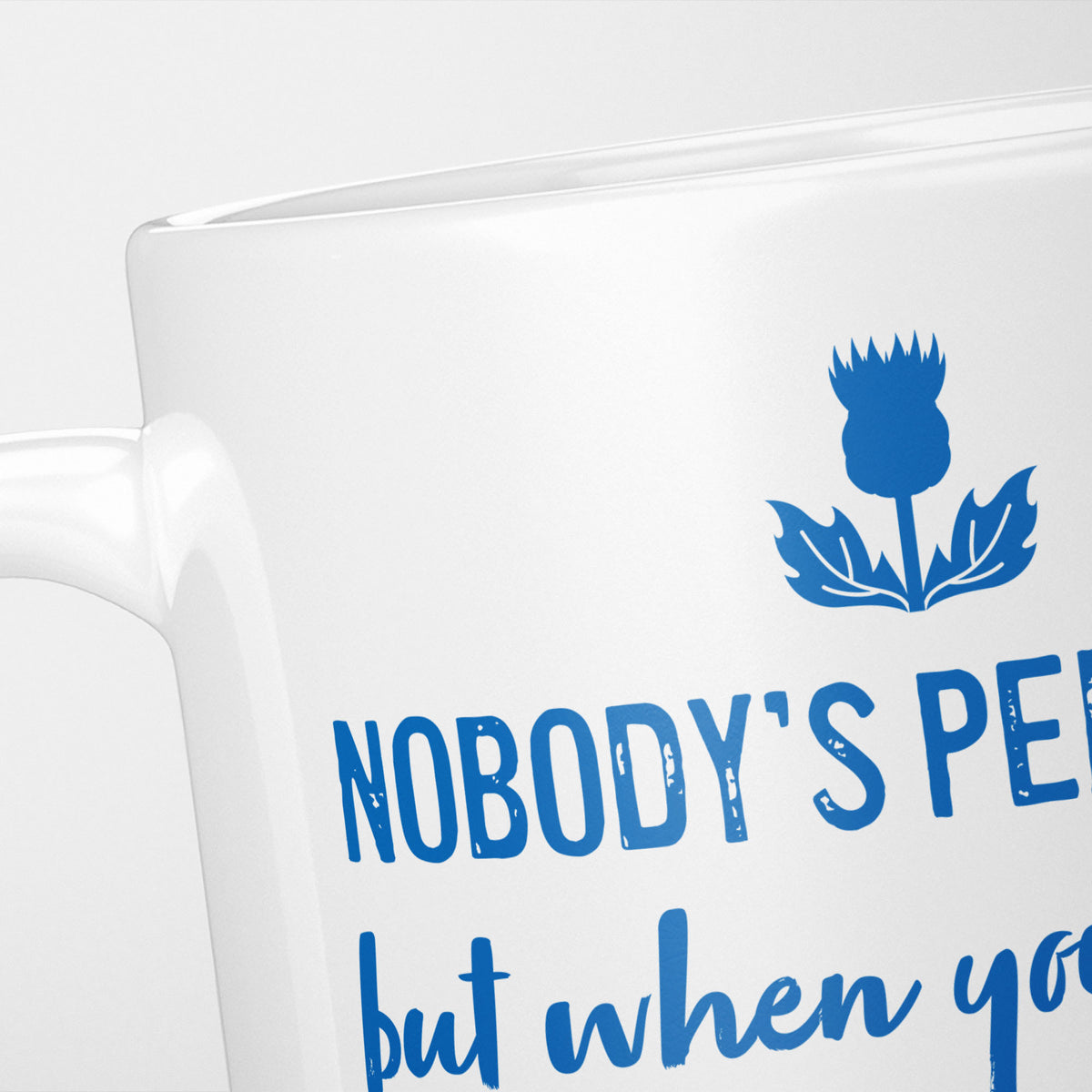 Close crop of the Nobody's Perfect Scotland mug, the blue thistle above 'Nobody's per…'