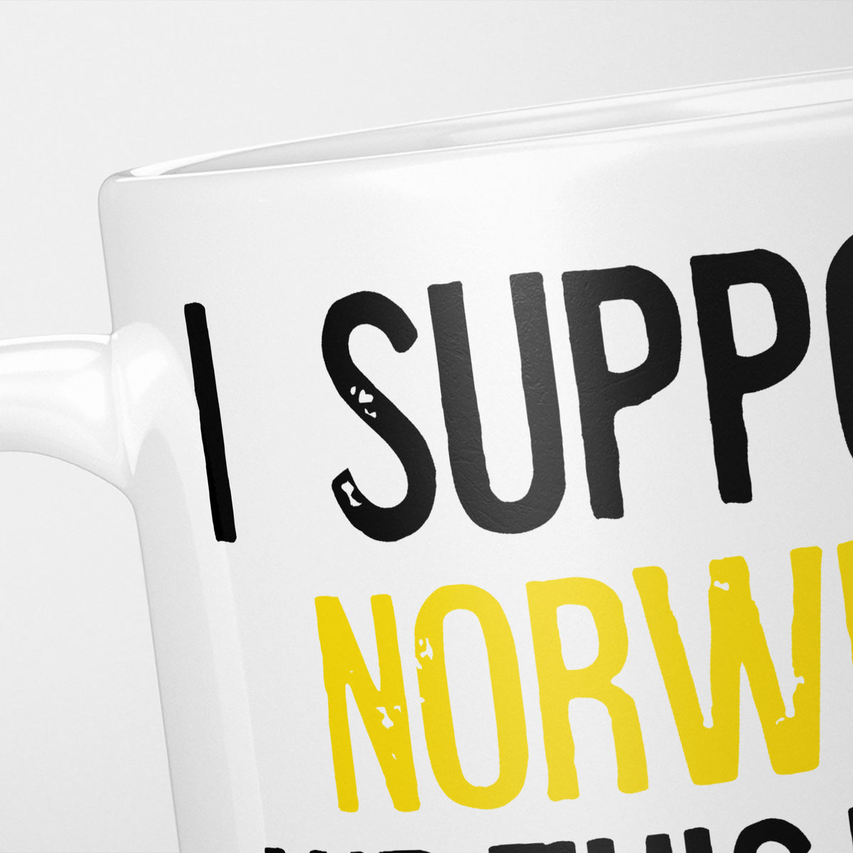 Close crop of the I Support Norwich mug, 'I Support' in heavy black above the club name in yellow, running off the edge of the frame