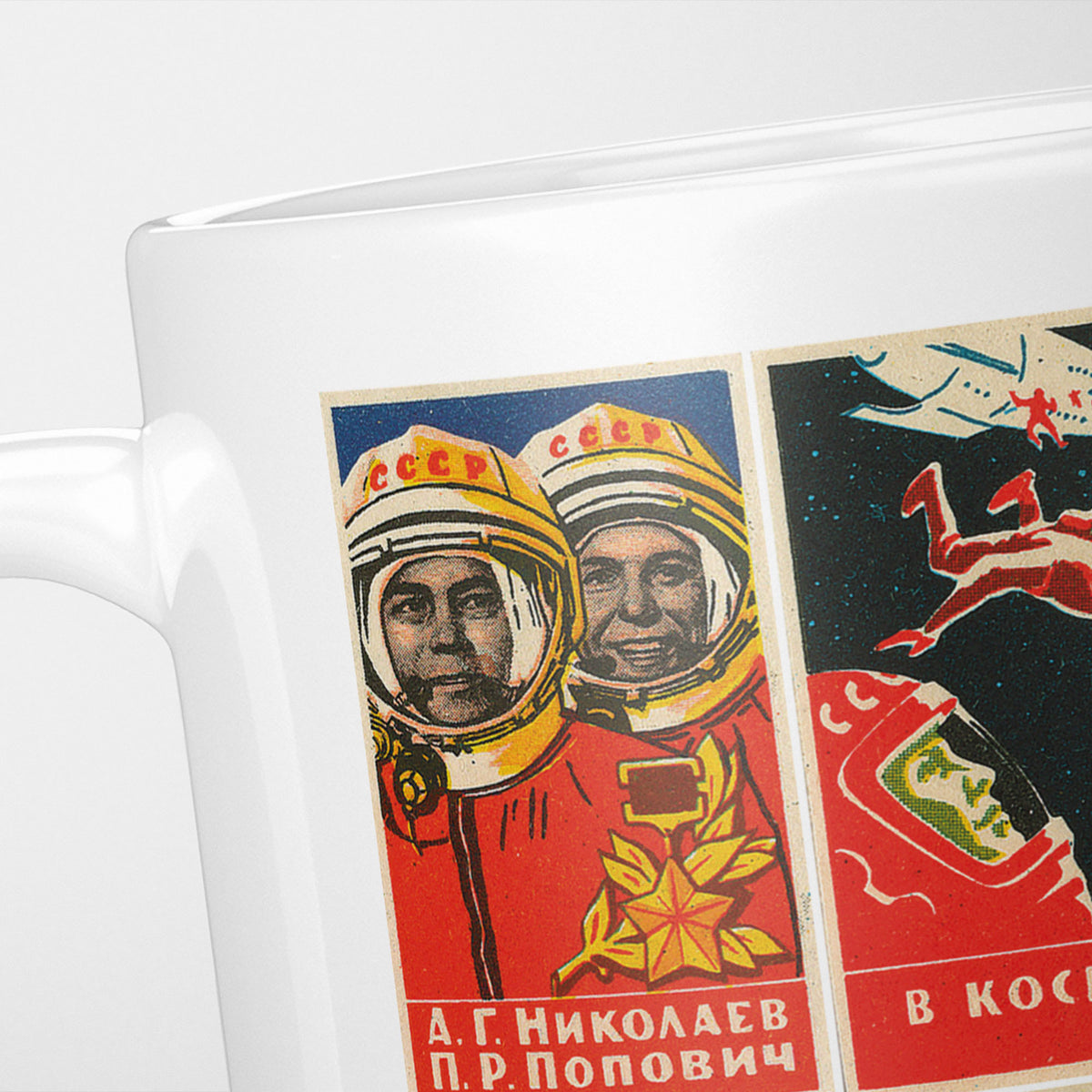 Close crop of the Russian Space Propaganda Posters mug, two cosmonauts in helmets beside a red rocket panel