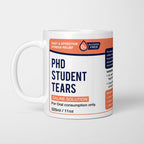White ceramic mug with a navy pharmacy-style label reading 'PhD Student Tears — Saline Solution, for oral consumption only'