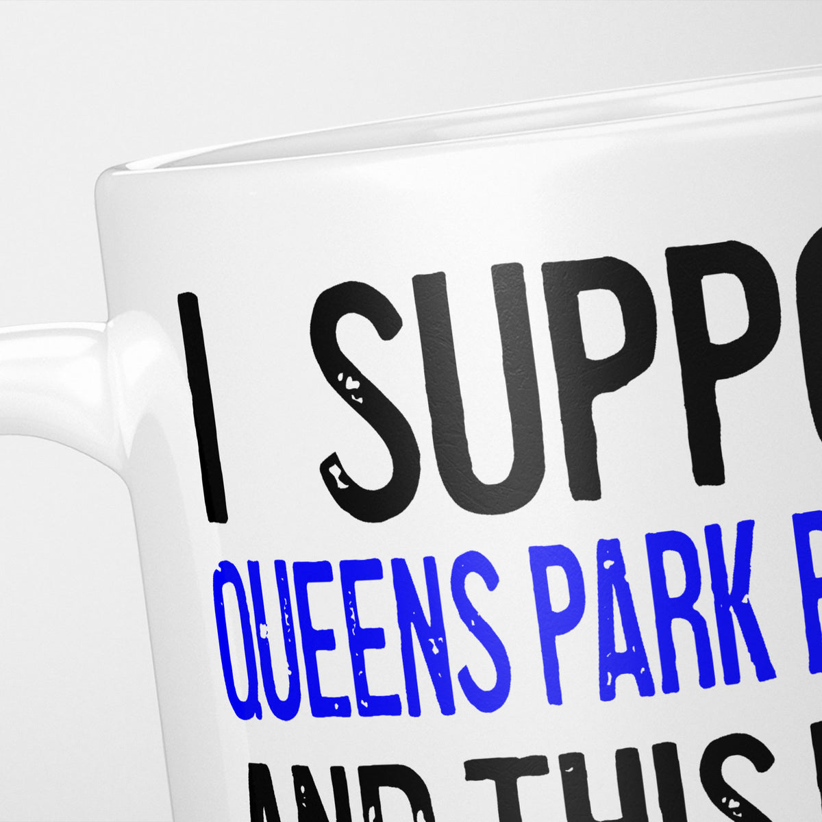 Close crop of the I Support Queens Park Rangers mug, 'I Support' in heavy black above the club name in blue, running off the edge of the frame