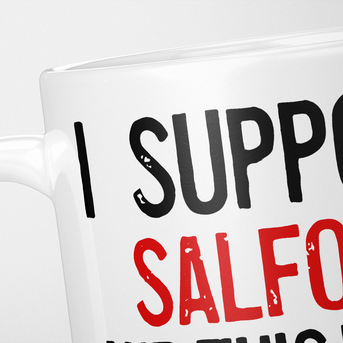 Close crop of the I Support Salford mug, 'I Support' in heavy black above the club name in red, running off the edge of the frame
