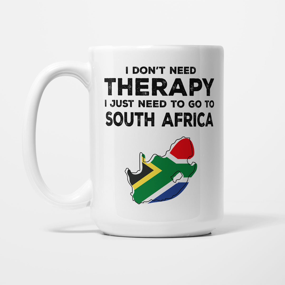 The 15oz I Need South Africa mug, white ceramic in bold black type reading 'I don't need therapy, I just need to go to SOUTH AFRICA', above an outline of South Africa filled with its national flag