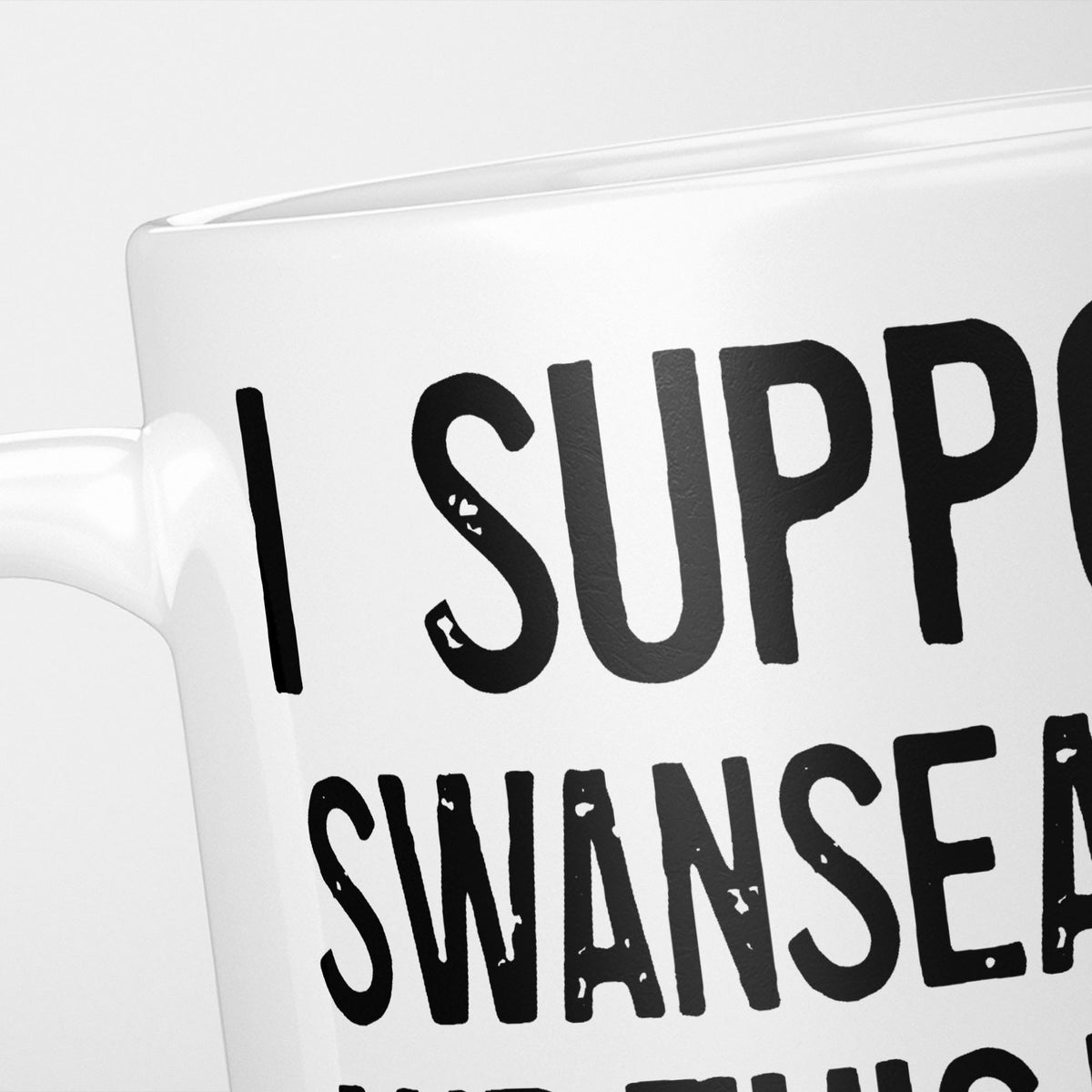 Close crop of the I Support Swansea City mug, 'I Support' above the club name in heavy black type, running off the edge of the frame