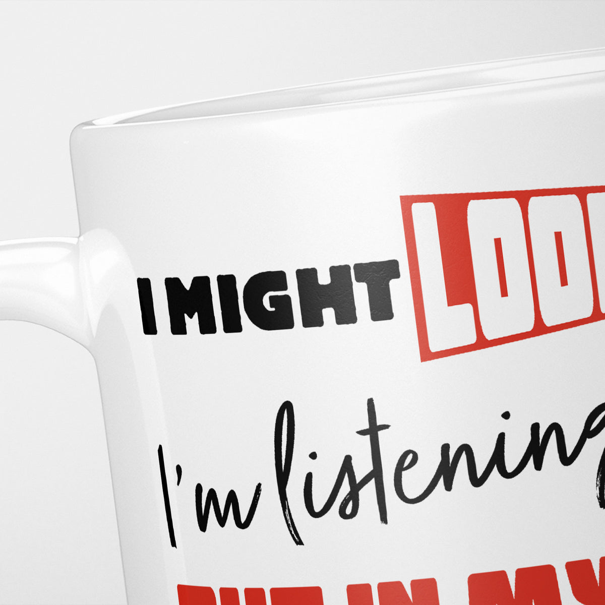 Close crop of the I'm Thinking About Ducks mug, 'I might look like' in black and red above a script 'I'm listening', with 'but in my head I'm thinking about Ducks' running out of frame