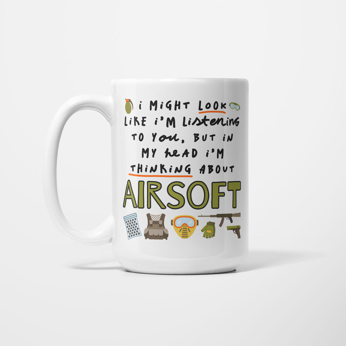 White 15oz ceramic mug, hand-lettered "I might look like I'm listening to you, but in my head I'm thinking about Airsoft" in olive green with orange underlines, illustrated with a BB pellet tub, tactical vest, yellow face mask, gloves, rifle and pistol