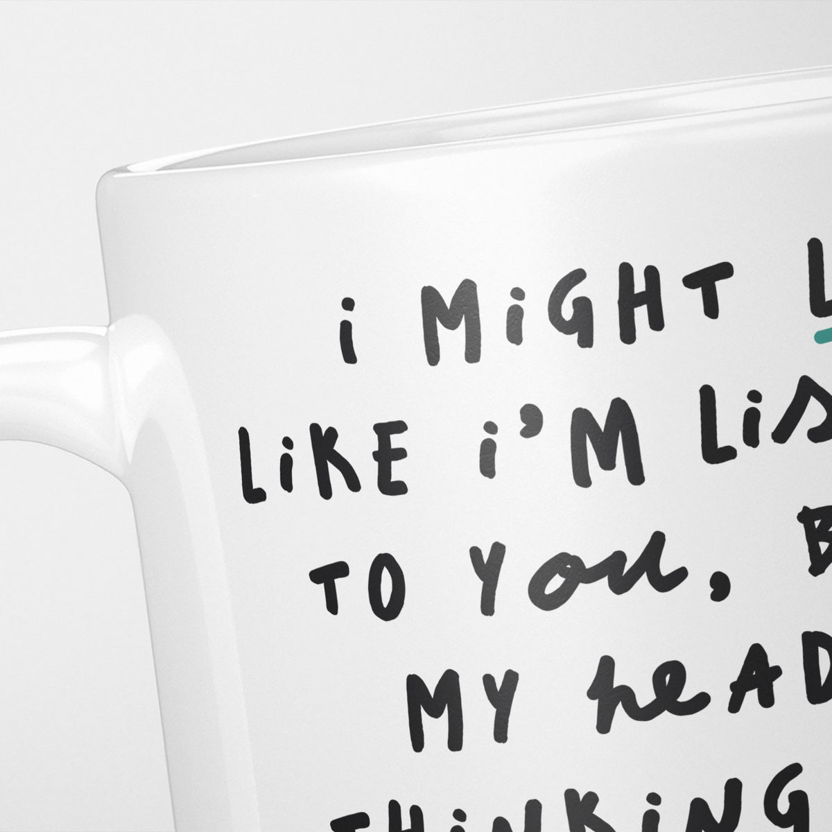 Close crop of the I'm Thinking About Pigeons mug, the opening of the hand-lettered text running off the frame, underlined in teal