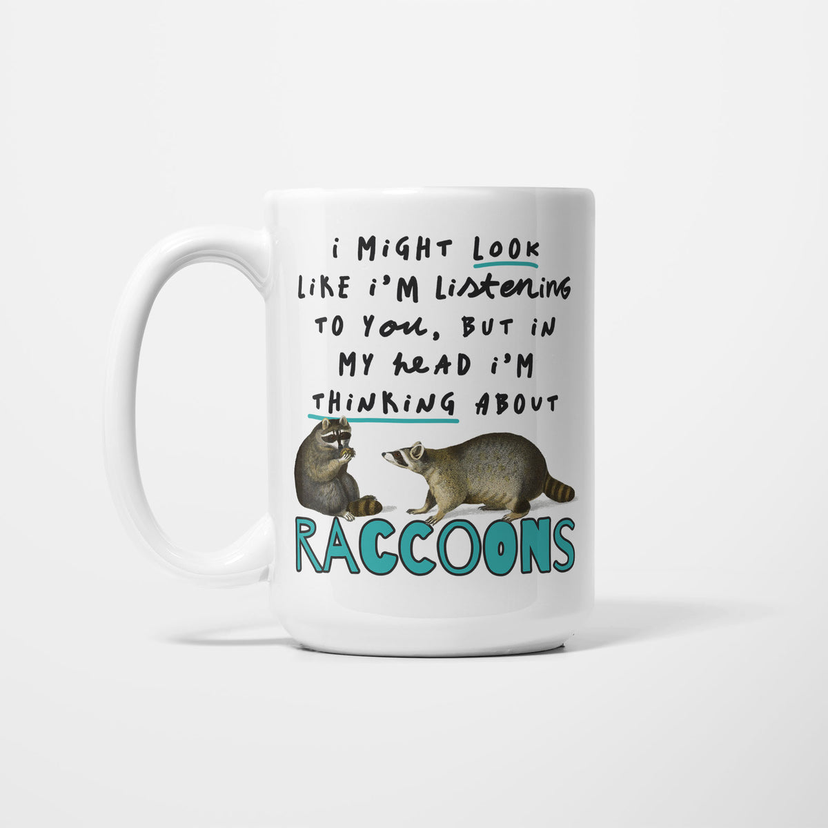 White 15oz ceramic mug, hand-lettered "I might look like I'm listening to you, but in my head I'm thinking about Raccoons" in teal, illustrated with two detailed raccoons, one sitting and one standing