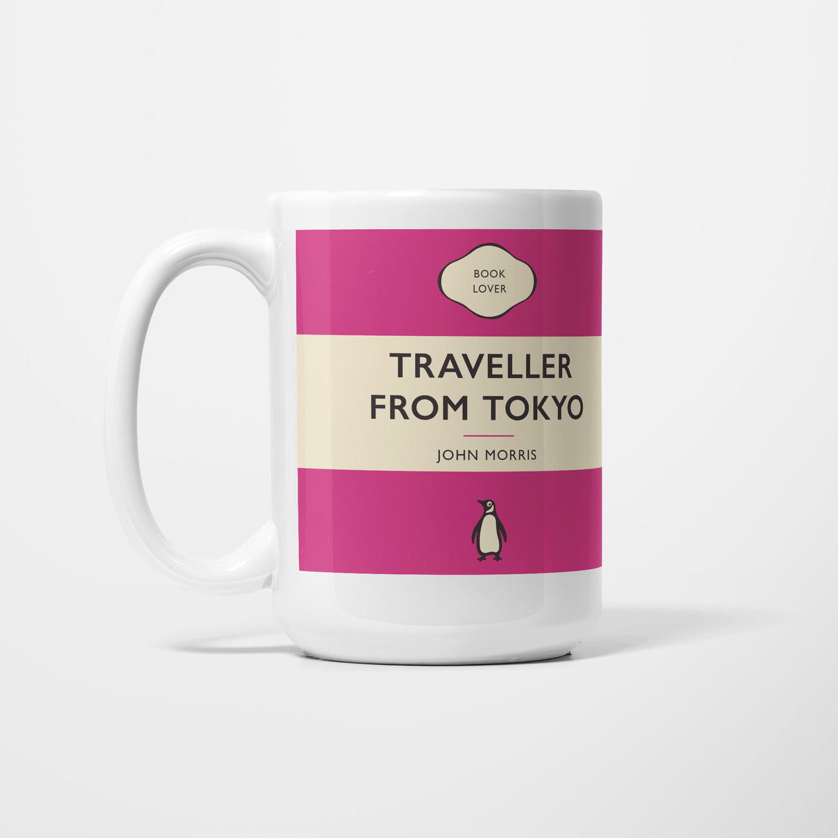 The 15oz Traveller from Tokyo mug, white ceramic printed as a vintage paperback jacket in magenta and cream, reading 'Traveller from Tokyo' above John Morris