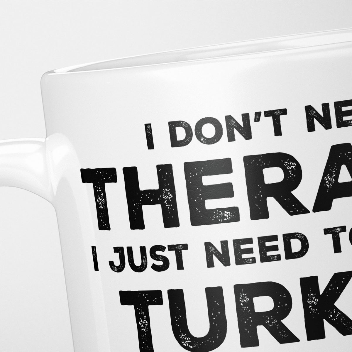 Close crop of the I Need Turkey mug, 'I don't need therapy, I just need to go to TURKEY' in heavy distressed black type, running off the edges of the frame