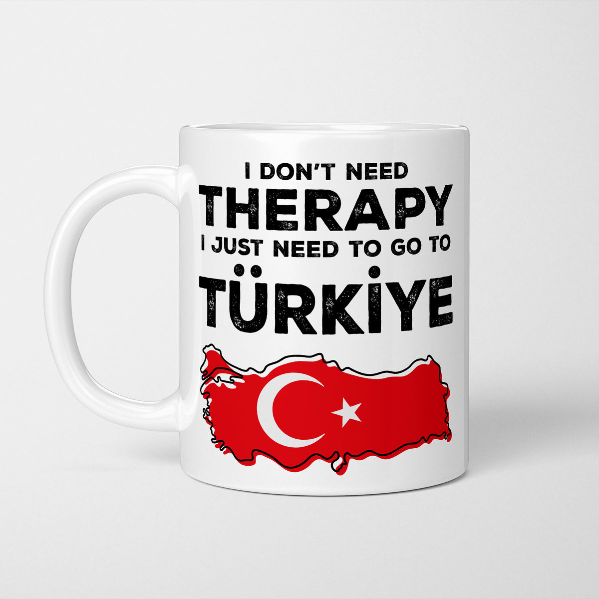 White ceramic mug in bold black type reading 'I don't need therapy, I just need to go to TÜRKİYE', above an outline of Türkiye filled with its national flag