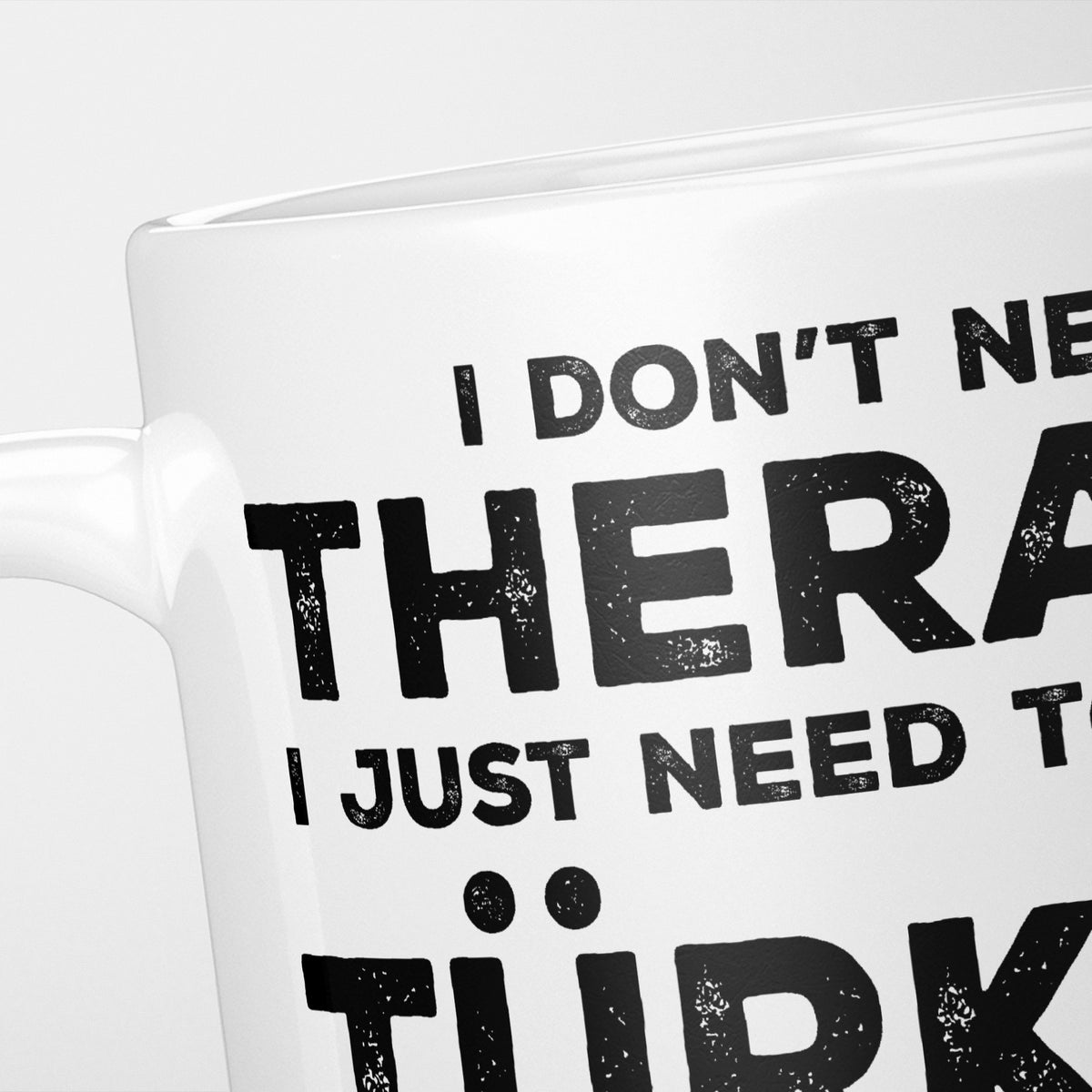 Close crop of the I Need Türkiye mug, 'I don't need therapy, I just need to go to TÜRKİYE' in heavy distressed black type, running off the edges of the frame