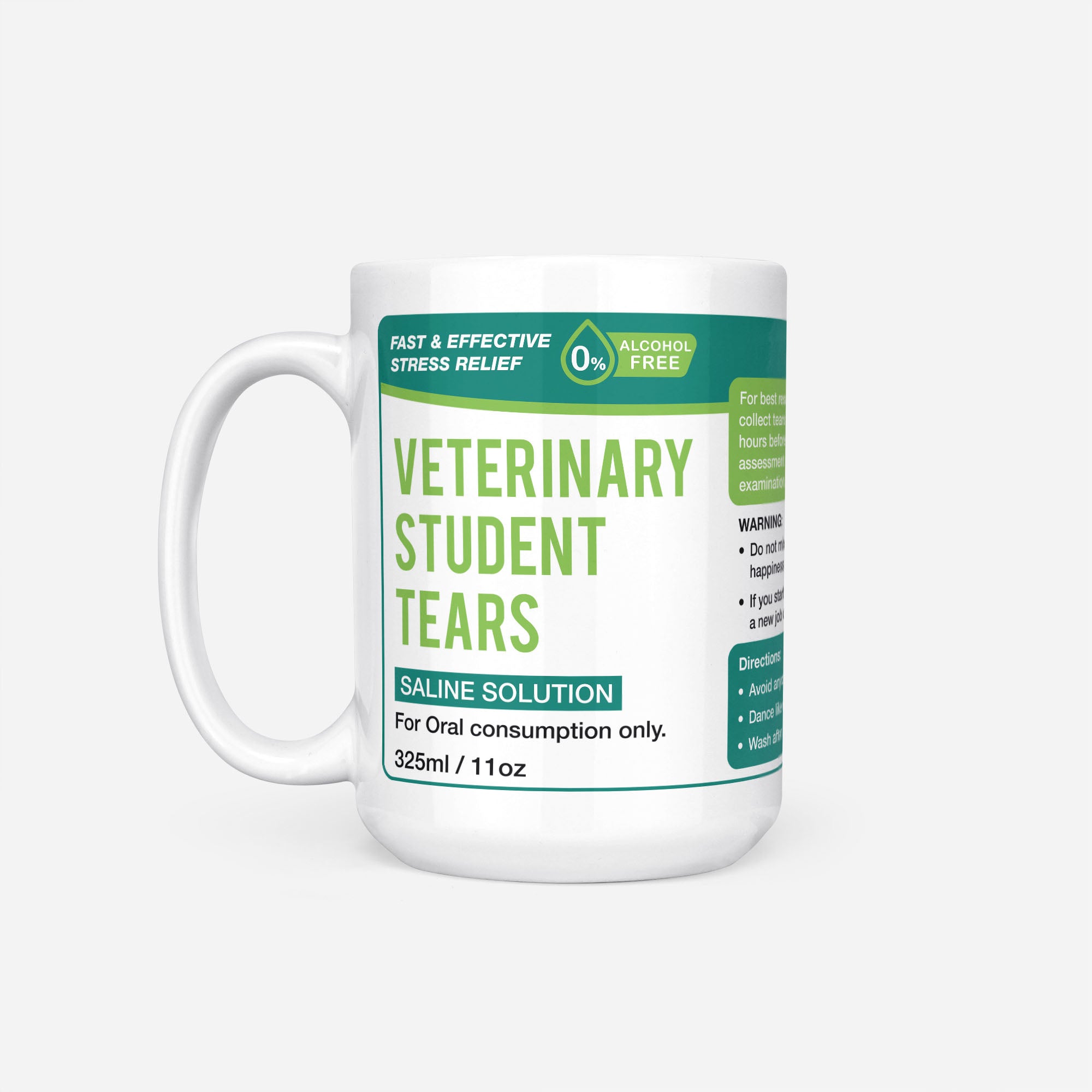 The 15oz Veterinary Student Tears mug, white ceramic with a dark green pharmacy-style label reading 'Veterinary Student Tears — Saline Solution, for oral consumption only'
