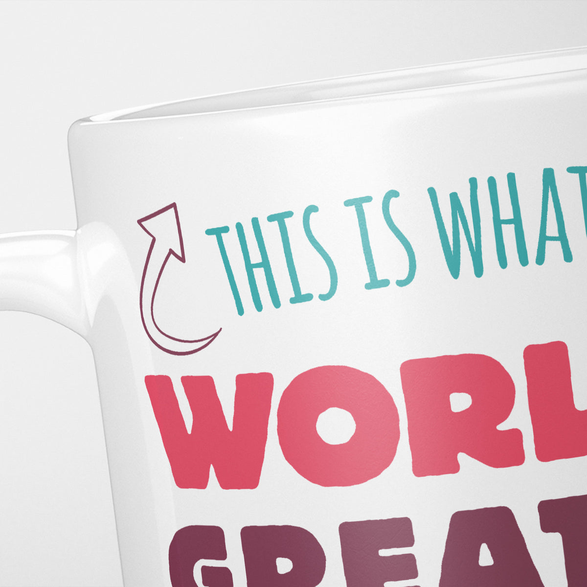 Close crop of the World's Greatest Cousin mug, 'This is what' in teal above 'World's Great…' in pink and plum beside a curved arrow, with 'Cousin looks like' cropped out of frame