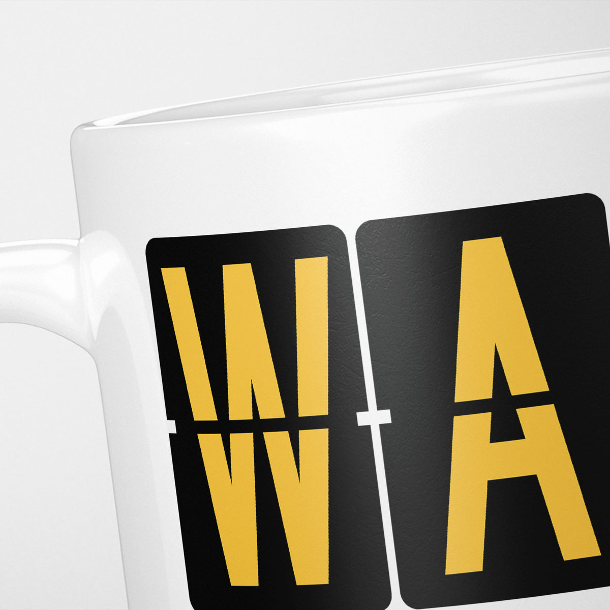 Close crop of the Warsaw Airport Tag mug, gold split-flap tiles reading 'W' and 'A' on black — the first two letters of WAW
