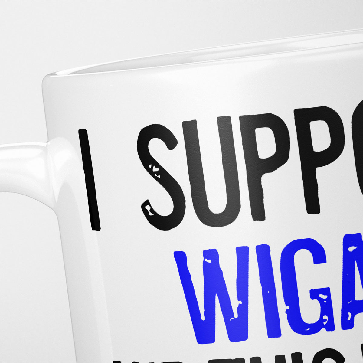 Close crop of the I Support Wigan mug, 'I Support' in heavy black above the club name in blue, running off the edge of the frame