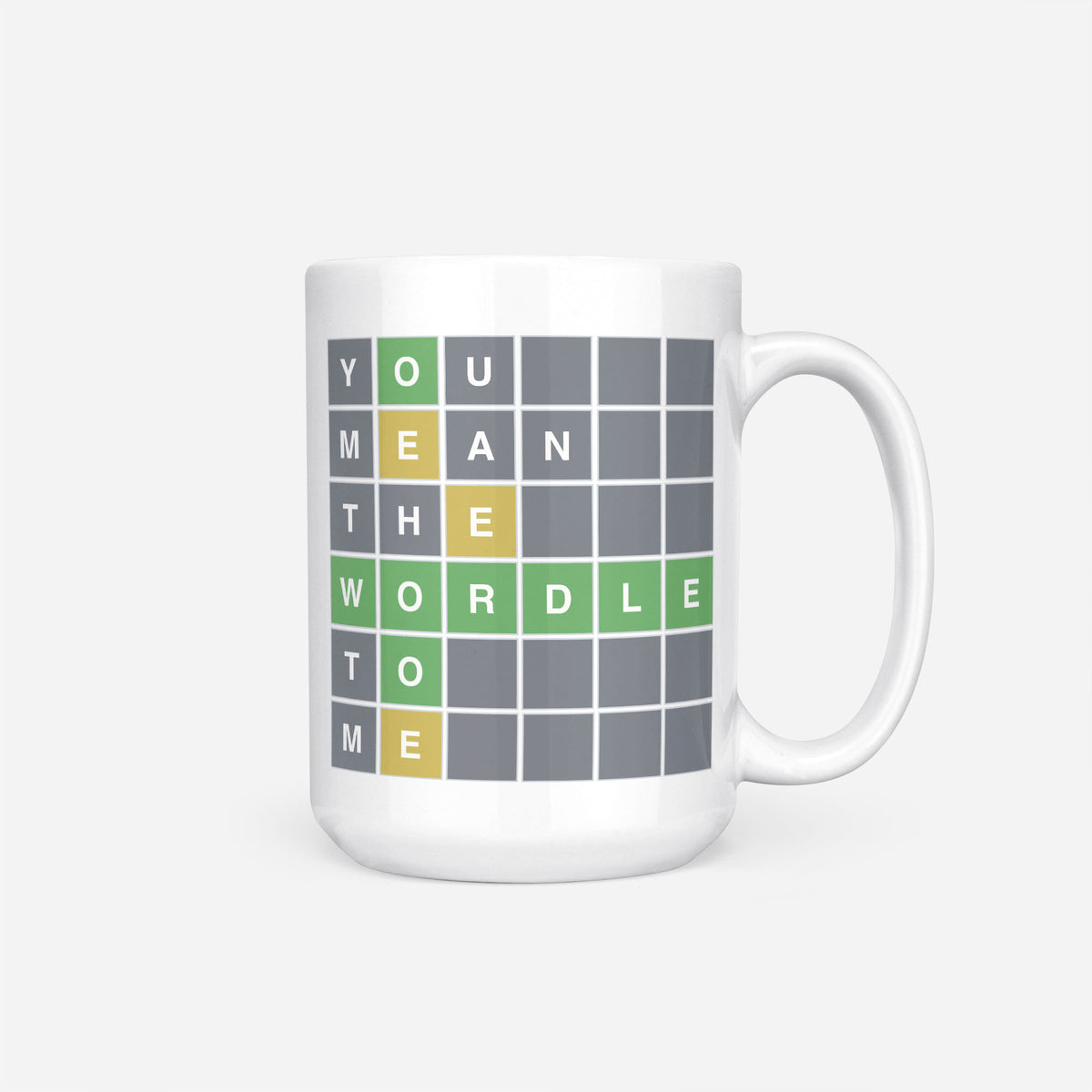 The 15oz You Mean The Wordle To Me mug, white ceramic printed with a Wordle-style grid spelling out 'You mean the Wordle to me' in green, yellow and grey tiles