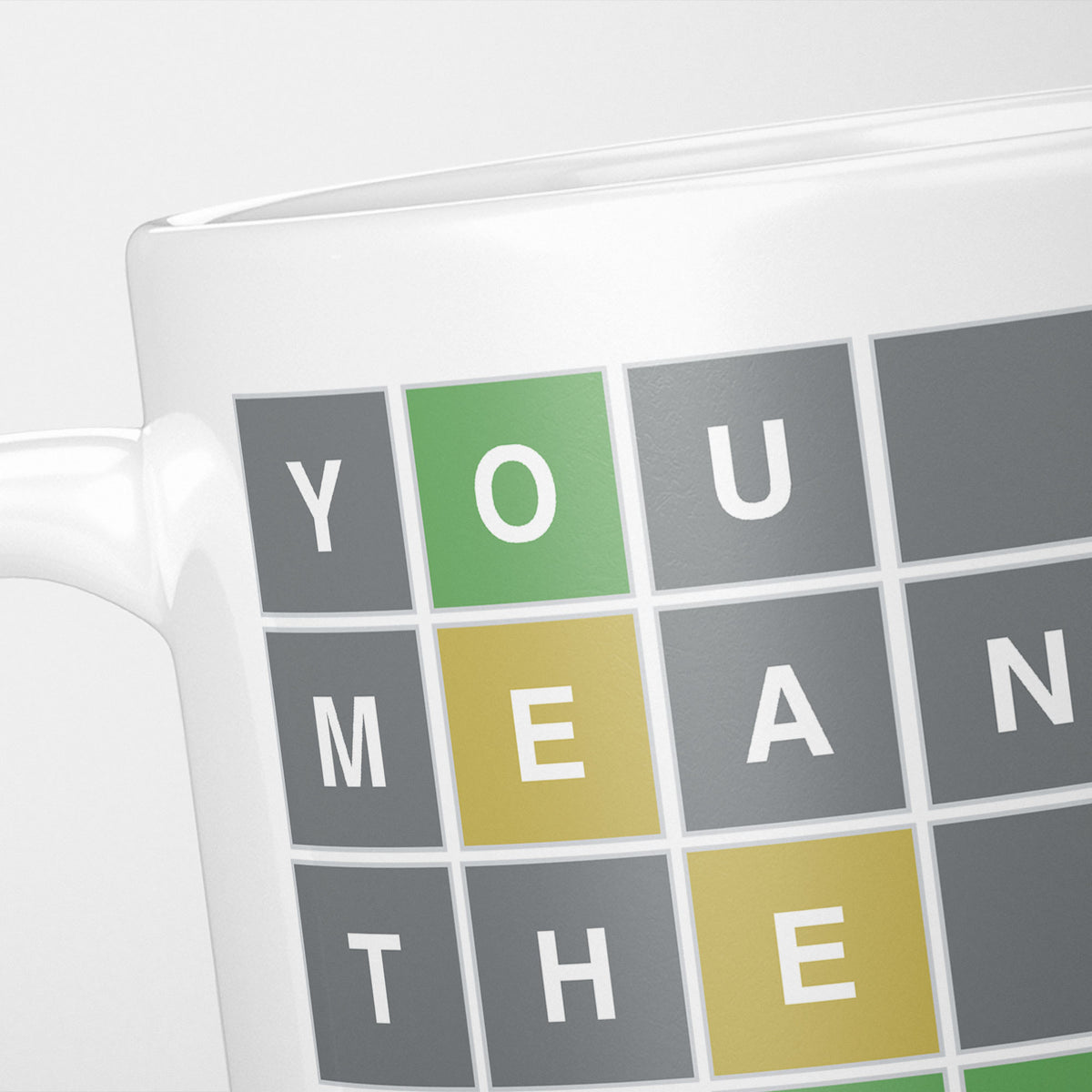 Close crop of the You Mean The Wordle To Me mug, tiles spelling YOU, MEAN and THE