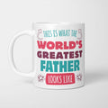 White ceramic mug in retro pink, plum and teal typography reading 'This is what the World's Greatest Father looks like', with two curved arrows pointing up at the person holding it and starbursts either side