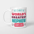White ceramic mug in retro pink, plum and teal typography reading 'This is what the World's Greatest Nephew looks like', with two curved arrows pointing up at the person holding it and starbursts either side