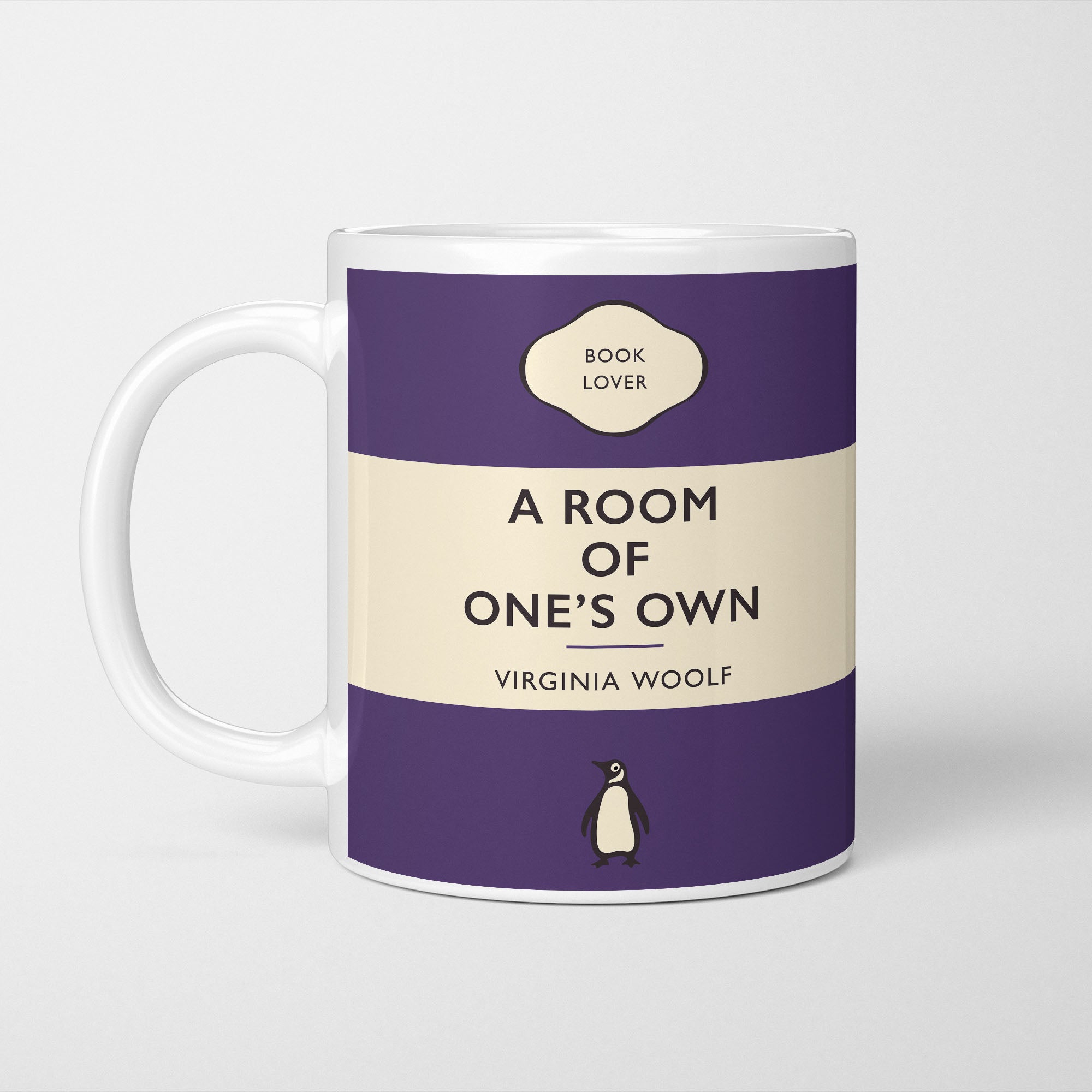 White ceramic mug printed with a vintage-style book cover design reading 'A Room of One's Own' by Virginia Woolf