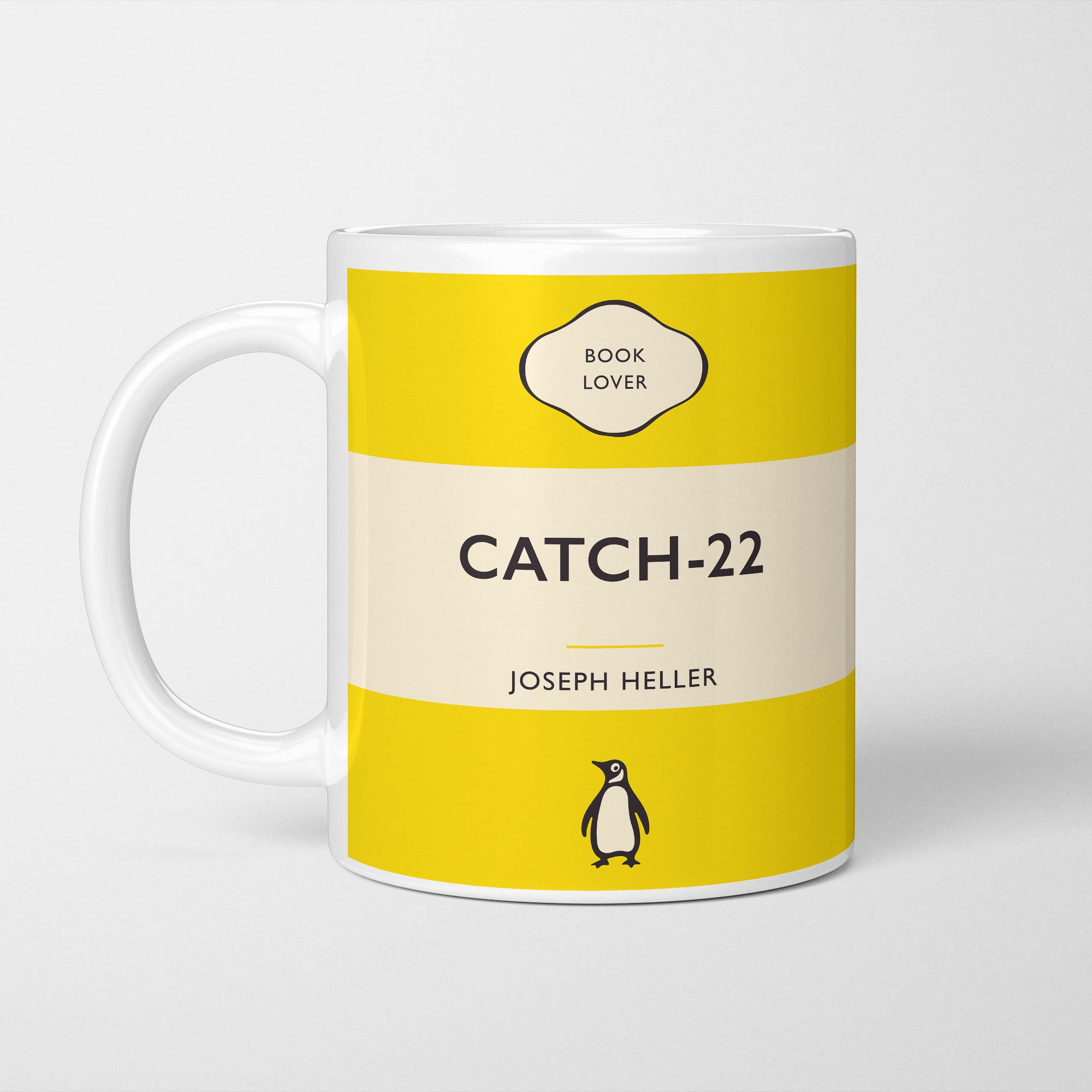 White ceramic mug printed with a vintage-style book cover design reading 'Catch 22' by Joseph Heller