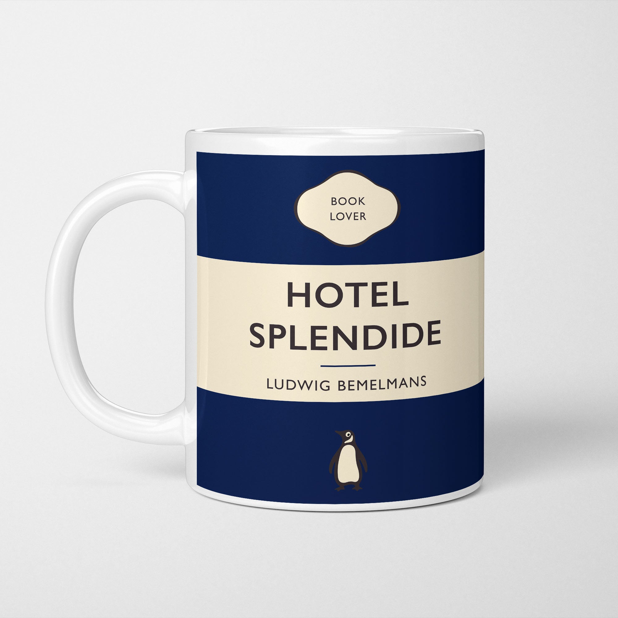 White ceramic mug printed with a vintage-style book cover design reading 'Hotel Splendide' by Ludwig Bemelmans