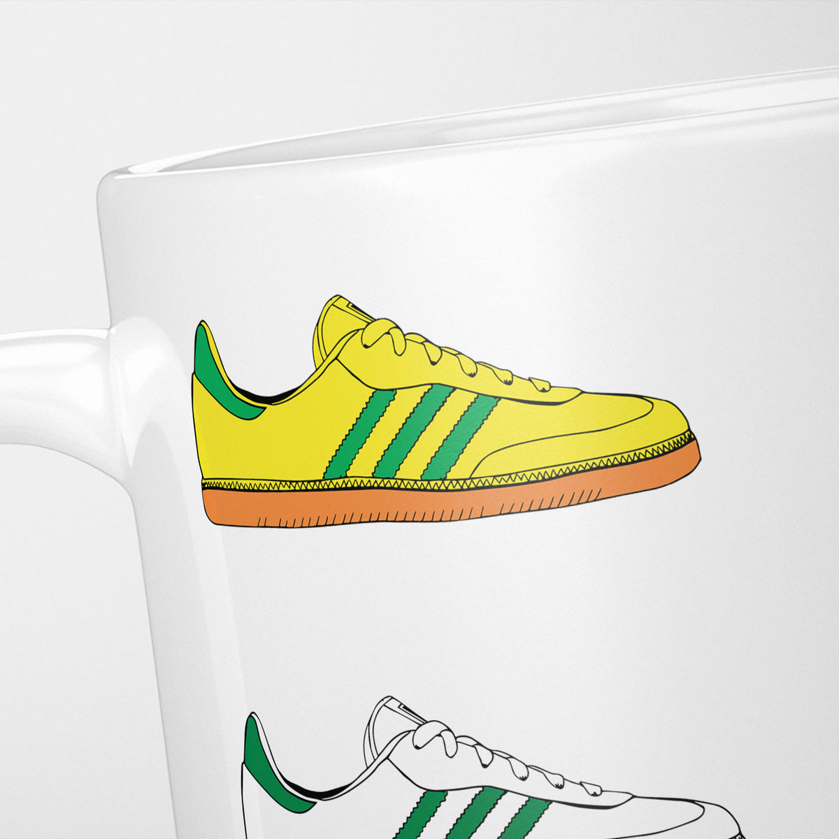 Close crop of the Sneakerhead Originals mug, a yellow and green trainer above a white and green one